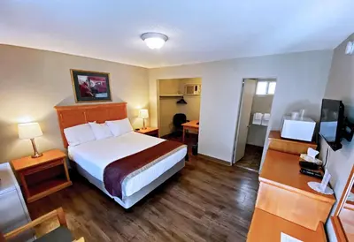 a hotel room with a bed and a television at Silver Star Motel in Vernon