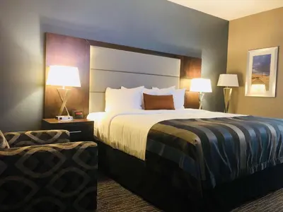 a hotel room with a large bed and two lamps at Wingate by Wyndham Kamloops in Kamloops