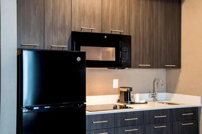 a kitchen with a black refrigerator and a microwave at Wingate by Wyndham Kamloops in Kamloops