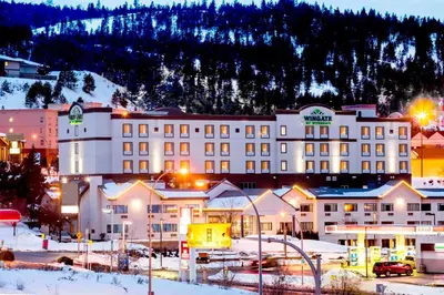 a large hotel in the snow at night at Wingate by Wyndham Kamloops in Kamloops