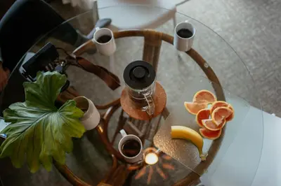 a table with cups of coffee and oranges on it at The Shoreline Tofino in Tofino