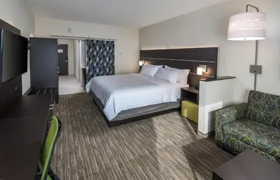 a hotel room with a bed and a couch at Holiday Inn Express & Suites Kelowna - East by IHG in Kelowna