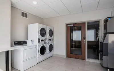 a laundry room with three washer and dryer at Holiday Inn Express & Suites Kelowna - East by IHG in Kelowna
