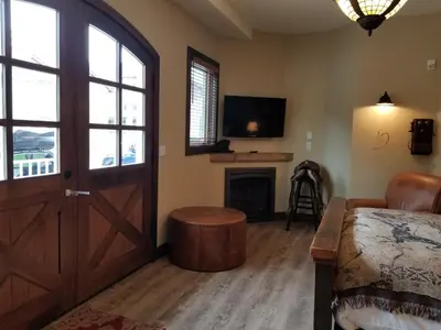 a living room with a door and a fireplace at Lady MacDonald Country Inn in Canmore