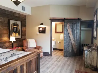 a bedroom with a bed and a sliding barn door at Lady MacDonald Country Inn in Canmore