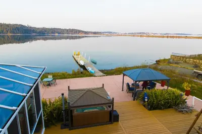 a deck with a view of a body of water at Birds of a Feather Victoria Oceanfront Studio Suites in Colwood