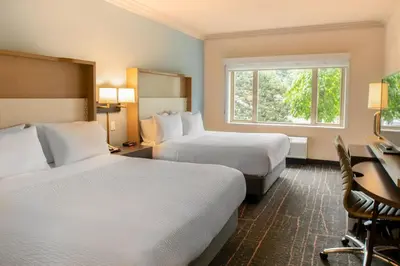a hotel room with two beds and a desk at Holiday Inn Victoria - Elk Lake by IHG in Victoria