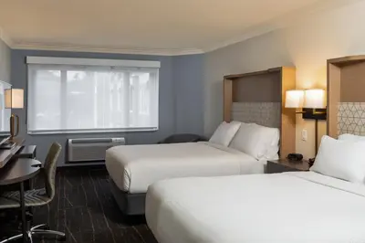 a hotel room with two beds and a desk at Holiday Inn Victoria - Elk Lake by IHG in Victoria