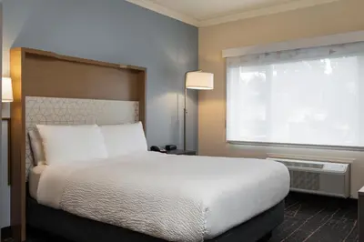 a bedroom with a large bed and a window at Holiday Inn Victoria - Elk Lake by IHG in Victoria