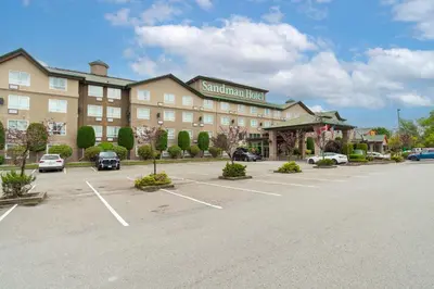 a hotel with a parking lot in front of it at Sandman Hotel Langley in Langley