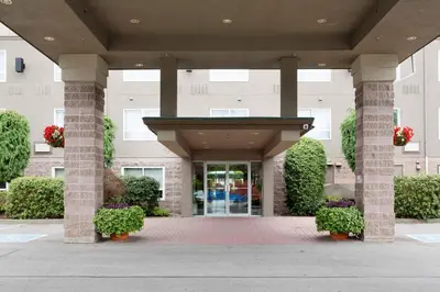 a lobby of a building with pillars and plants at Sandman Hotel Langley in Langley