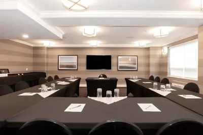 a conference room with tables and chairs and a flat screen tv at Sandman Hotel Langley in Langley