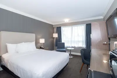 a hotel room with a bed and a television at Sandman Hotel Langley in Langley