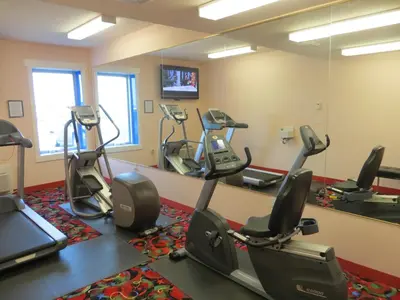a gym with several treadmills and elliptical machines at Crystal Star Inn Edmonton Airport with free shuttle to and from Airport in Leduc