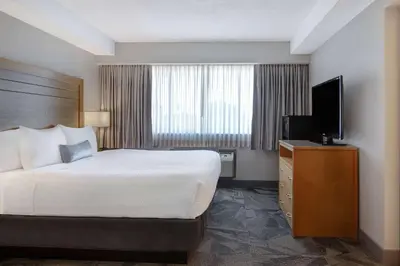 a hotel room with a bed and a flat screen tv at Days Inn by Wyndham Victoria Airport Sidney in Sidney