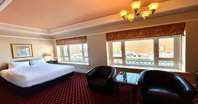 a hotel room with a bed and two chairs at The Bedford Regency Hotel in Victoria