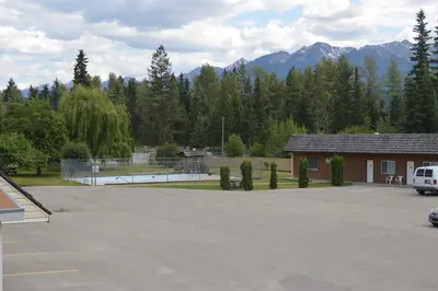 a parking lot with a tennis court and a building at Mary's Motel in Golden