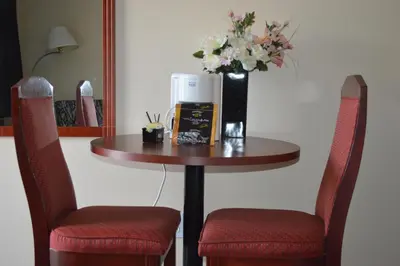 a table with two chairs and a vase with flowers on it at Mary's Motel in Golden