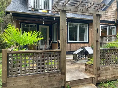 a wooden deck with a pergola on a house at Sienna's Tree House (Tall Trees And Salty Breeze) in Tofino