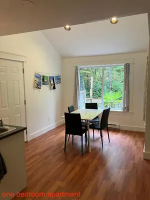 a kitchen and dining room with a table and chairs at Sienna's Tree House (Tall Trees And Salty Breeze) in Tofino