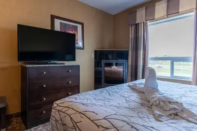 a bedroom with a bed and a flat screen tv at Best Western Plus South Edmonton Inn & Suites in Edmonton