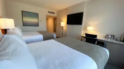a hotel room with two beds and a flat screen tv at Coast Capri Hotel in Kelowna