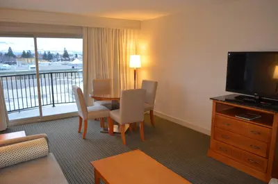a hotel room with a table and a television at Coast Capri Hotel in Kelowna
