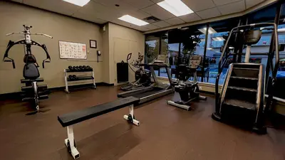 a gym with treadmills and machines in a room at Coast Capri Hotel in Kelowna