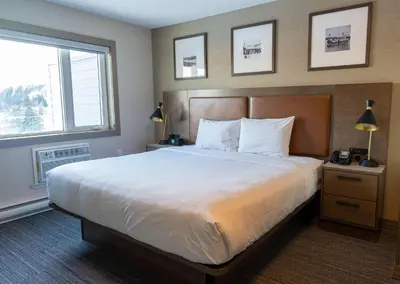 a bedroom with a large bed and two windows at Best Western Gold Rush Inn in Whitehorse
