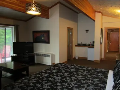 a hotel room with a bed and a flat screen tv at The Lodge At Skeena Landing in Terrace