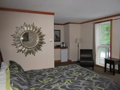 a bedroom with a bed and a mirror on the wall at The Lodge At Skeena Landing in Terrace