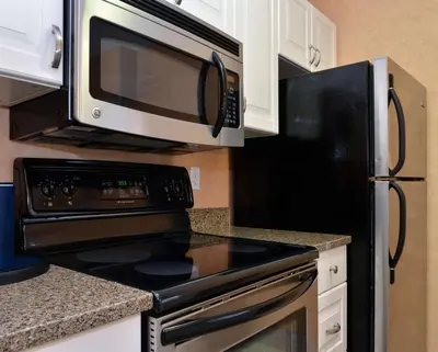 a kitchen with a microwave and a stove top oven at Best Western Plus Regency Inn and Conference Centre in Abbotsford