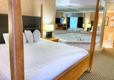 a hotel room with a bed and a bath tub at Best Western Plus Regency Inn and Conference Centre in Abbotsford
