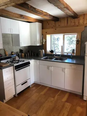 a kitchen with white cabinets and a stove top oven at Vines and Puppies Hideaway in Jade City