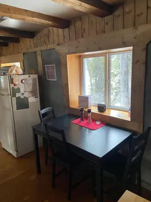 a dining room with a table and a refrigerator at Vines and Puppies Hideaway in Jade City