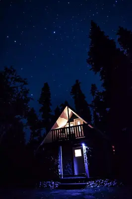 a small house lit up at night in the dark at Vines and Puppies Hideaway in Jade City