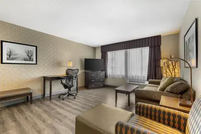a hotel room with a couch and a desk at Best Western Plus Country Meadows Inn in Aldergrove