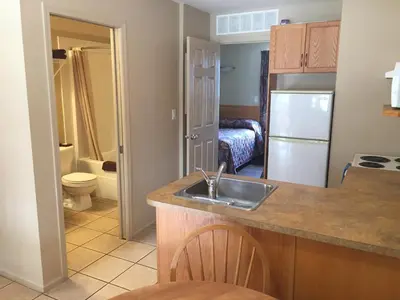 a kitchen with a sink and a bathroom with a bed at Avalon Inn in Osoyoos