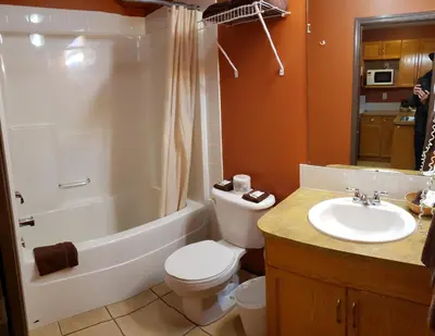 a bathroom with a toilet and a tub and a sink at Avalon Inn in Osoyoos