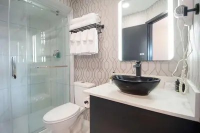 a bathroom with a sink and a toilet and a shower at Coast Courtenay Hotel in Courtenay