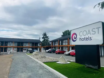 a sign in front of a building with a hotel at Coast Courtenay Hotel in Courtenay