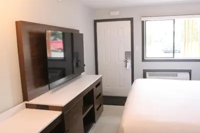 a bedroom with a bed and a flat screen tv at Coast Courtenay Hotel in Courtenay