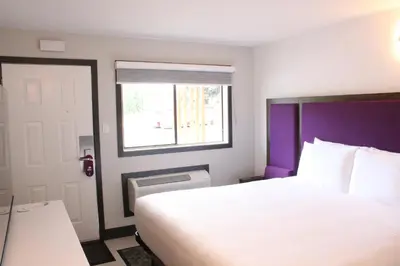 a bedroom with a white bed and a window at Coast Courtenay Hotel in Courtenay