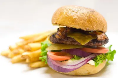 a cheeseburger with lettuce tomatoes and cheese and fries at Hilton Vancouver Airport in Richmond