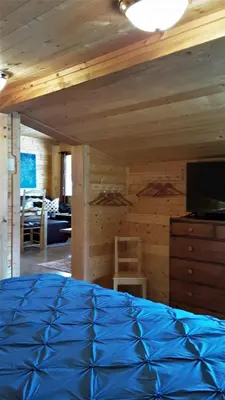a bedroom with a blue comforter on a bed at Tschurtschenthaler Lodge in Golden