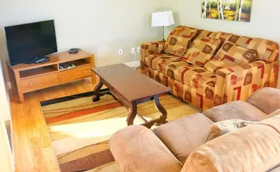 a living room with a couch and a table at Vedder River Inn in Chilliwack