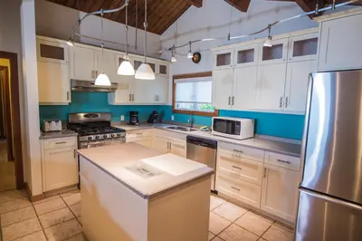 a kitchen with white cabinets and stainless steel appliances at Ocean Resort in Oyster Bay