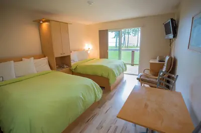 a hotel room with two beds and a television at Ocean Resort in Oyster Bay