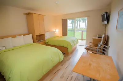 a hotel room with two beds and a window at Ocean Resort in Oyster Bay