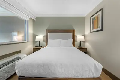 a bedroom with a white bed and two lamps at Best Western PLUS Burnaby Hotel in Burnaby